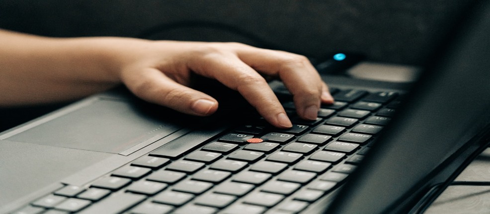 A professional working on a laptop, fostering innovation with effective knowledge collaboration tools