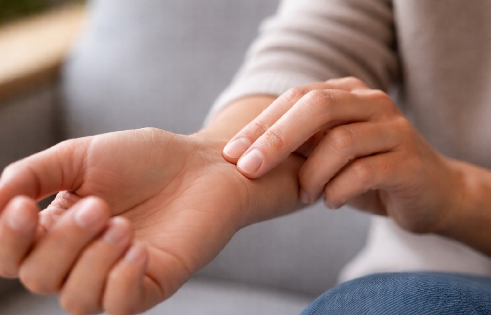 Fingers checking radial pulse on wrist